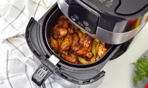 Skrzydełka kurczaka i frytki w frytkownicy beztłuszczowej.