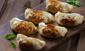 Złociste, chrupiące pierożki na desce. Idealne, gdy wiesz, jak usmażyć pierogi na patelni.