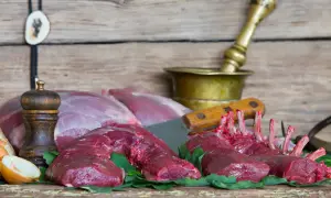 Surowe mięso sarny, żeberka i kawałki na desce. Zastanawiasz się, ile kosztuje sarna?