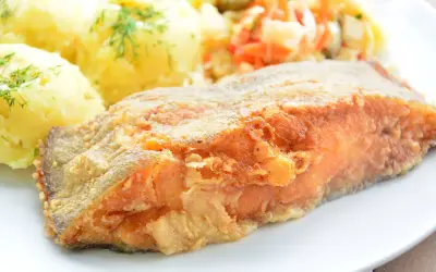 Złocisty, chrupiący kawałek ryby, idealny do nauki jak smażyć halibuta w dzwonkach. Podany z purée ziemniaczanym i surówką.
