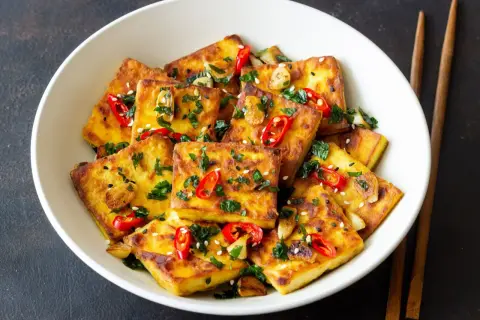 Złocisty, chrupiący tofu na patelni, posypany chili i sezamem. Idealny sposób, by dowiedzieć się, ile smażyć tofu na patelni dla najlepszego efektu.
