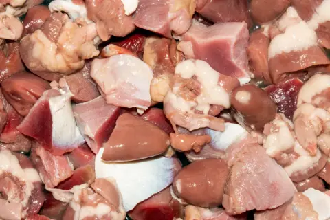 Kawałki surowego mięsa drobiowego, w tym serca i żołądki. Czy wątróbka to mięso? Tak, to podroby, które są częścią mięsa.