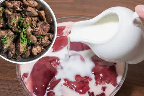 Surowa wątróbka w mleku, obok gotowa, posypana zieleniną. Czy wątróbkę można odgrzewać?