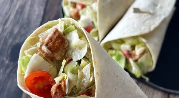 Pyszne tortille z kurczakiem, sałatą i pomidorkami. Idealne, gdy zastanawiasz się, jak podgrzać tortille z kurczakiem.