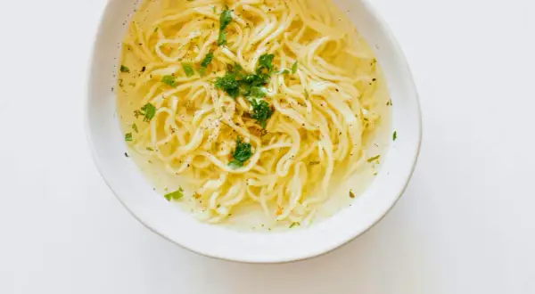 Miseczka z bulionem i makaronem, posypana natką. Czy maggi jest zdrowe? To pytanie nurtuje wielu.