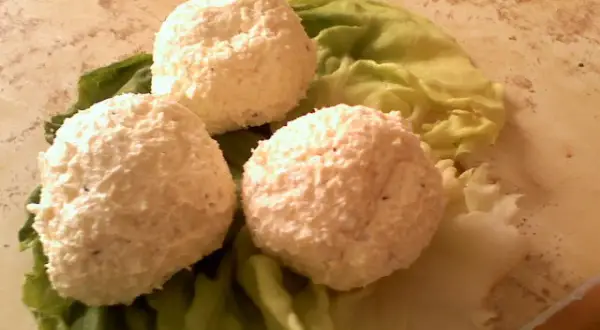 Trzy kulki serka fromage na liściach sałaty. Idealne na przekąskę, gdy wiesz, jak zrobić serek fromage.