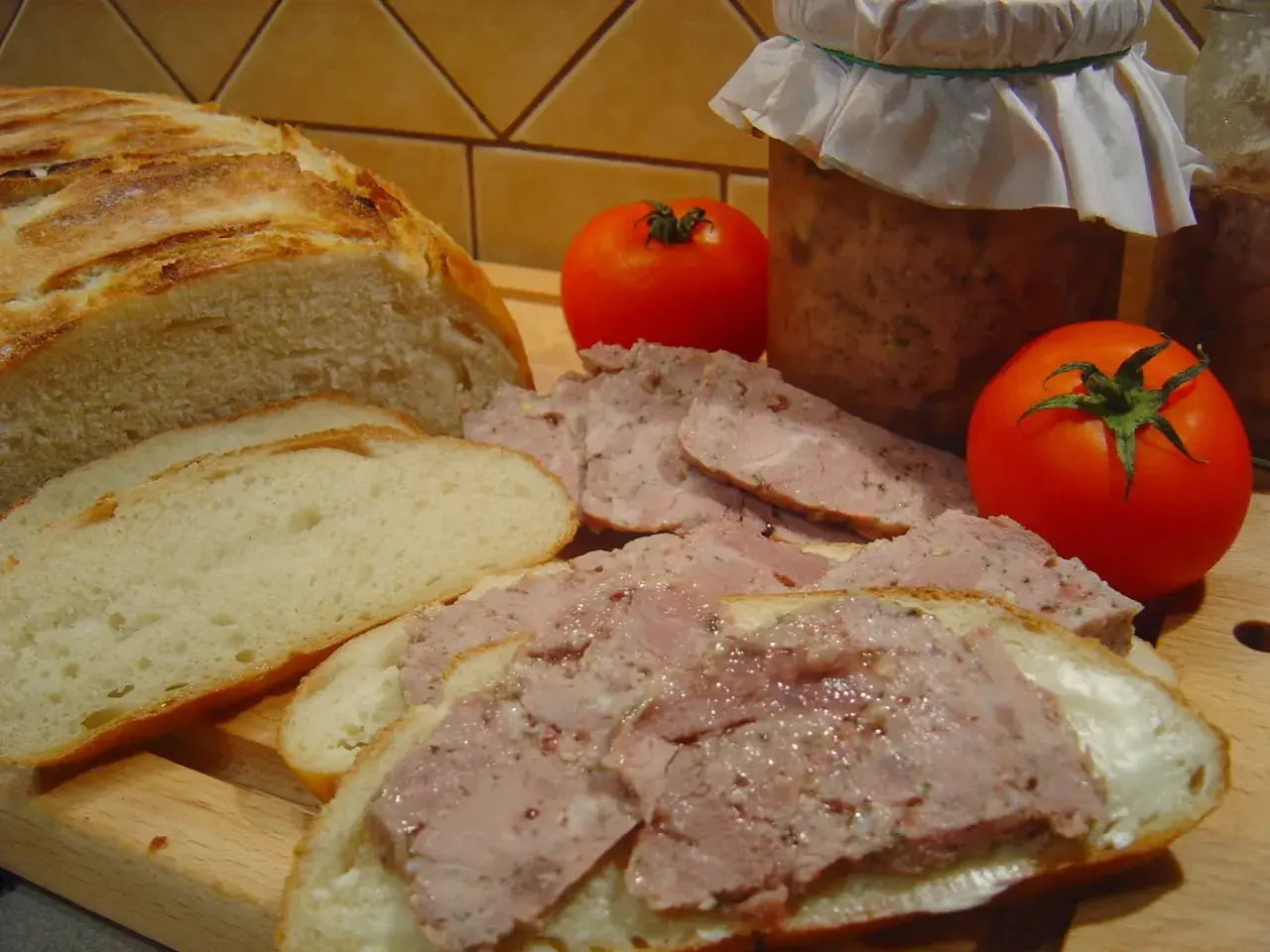 Chleb, pasztet, pomidory i słoik domowej kiełbasy. Zastanawiasz się, ile ziela angielskiego do kiełbasy?