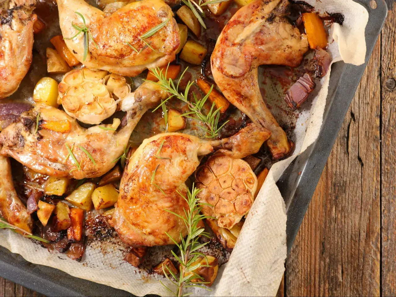 Pieczone ćwiartki z kurczaka z ziemniakami, marchewką i czosnkiem. Idealny sposób, by dowiedzieć się, ile gotować ćwiartki z kurczaka, by były soczyste.