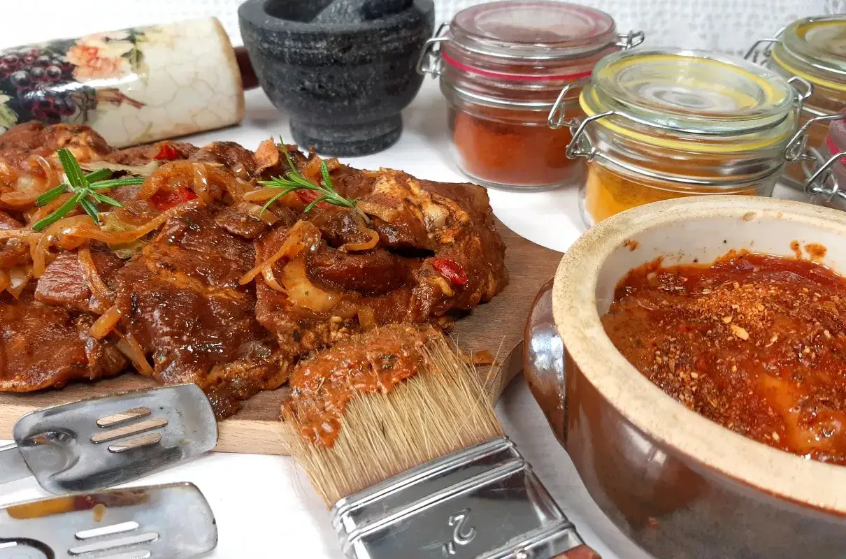 Pyszna marynata do karczku na grilla, gotowa do użycia. W tle przyprawy i moździerz.