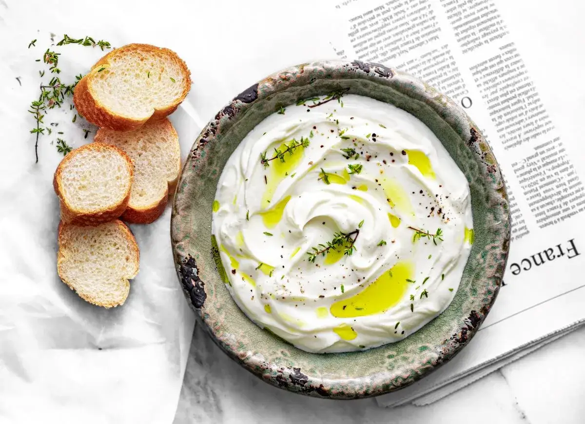 Kremowy serek fromage, polany oliwą i posypany ziołami, podany z kromkami bagietki. Idealny przepis na domowy serek fromage.