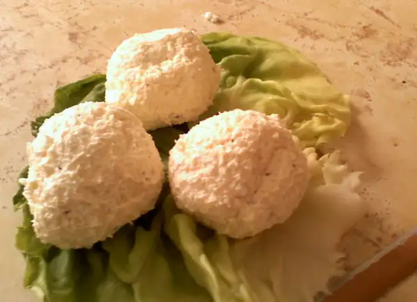 Trzy kulki serka fromage na liściach sałaty. Idealne na przekąskę, gdy wiesz, jak zrobić serek fromage.